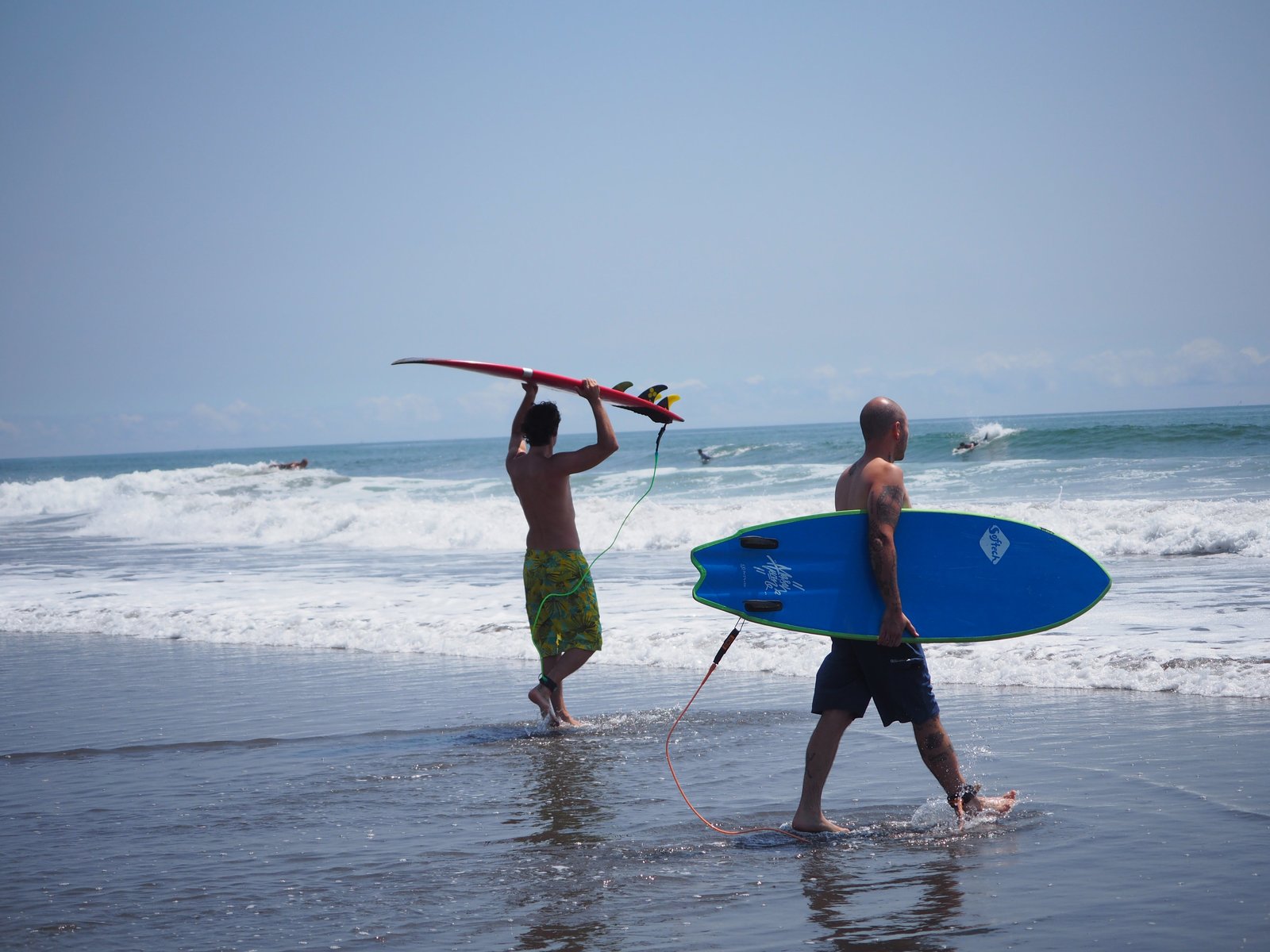 The Kaigan crew carrying surfboards into the waves at Minamiboso